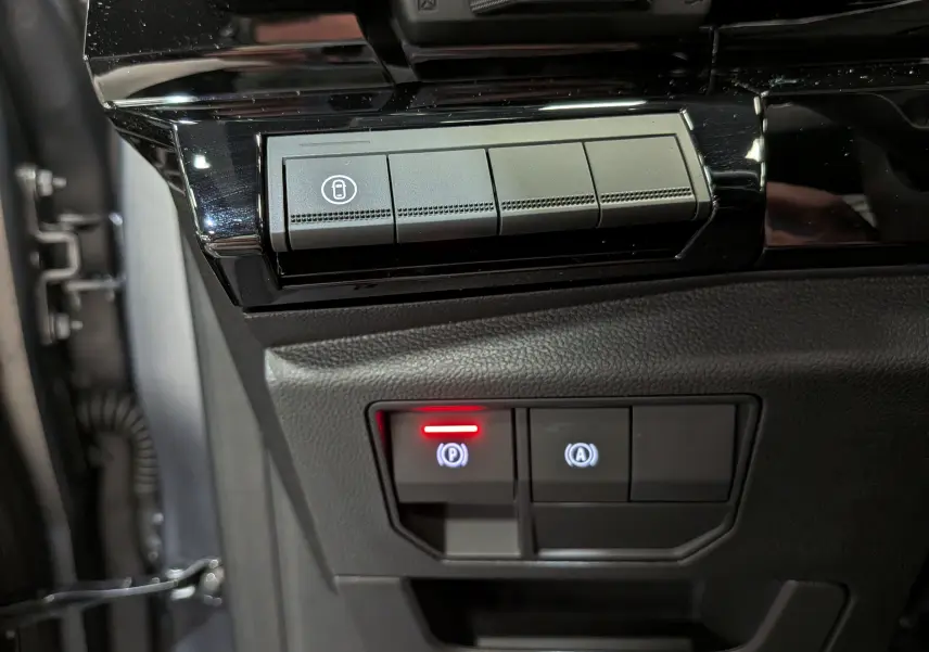 Gros plan sur les boutons de commande intérieurs noirs du Renault Rafale E-Tech, avec témoin rouge allumé.