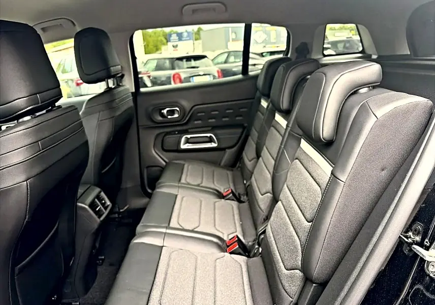 Vue intérieure de la 2e rangée de sièges individuels coulissants du Citroën C5 Aircross noir, avec habillage gris et noir.