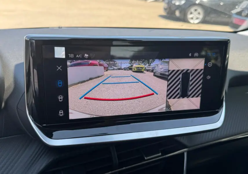 Écran tactile intérieur de la Peugeot 208 gris, affichant la caméra de recul avec lignes de guidage et vue 360° du véhicule.