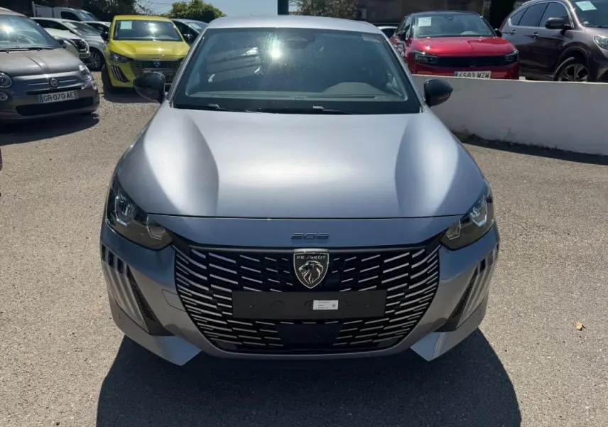 Vue avant d'une Peugeot 208 Hybrid 110 gris métallisé avec calandre noire et logo lion central bien visible.