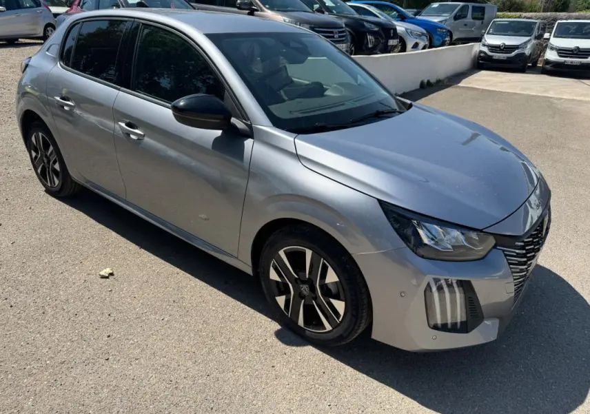 Peugeot 208 Hybrid gris vue 3/4 avant droit, avec jantes alliage 16 pouces et vitres teintées.