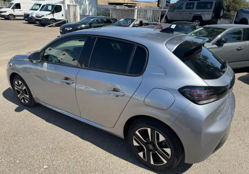 Peugeot 208 Hybrid gris vue 3/4 arrière droit, jantes alliage 16 pouces et feux arrière noirs distinctifs.