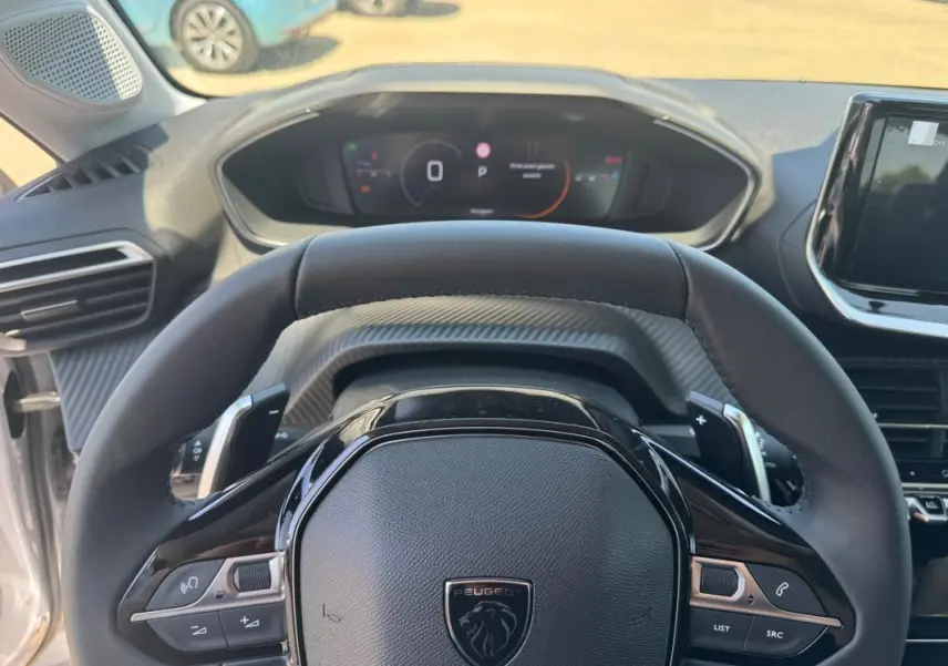 Vue rapprochée du volant cuir noir et du cockpit numérique de la Peugeot 208 Hybrid 110 e-DCS6 Allure 2025.