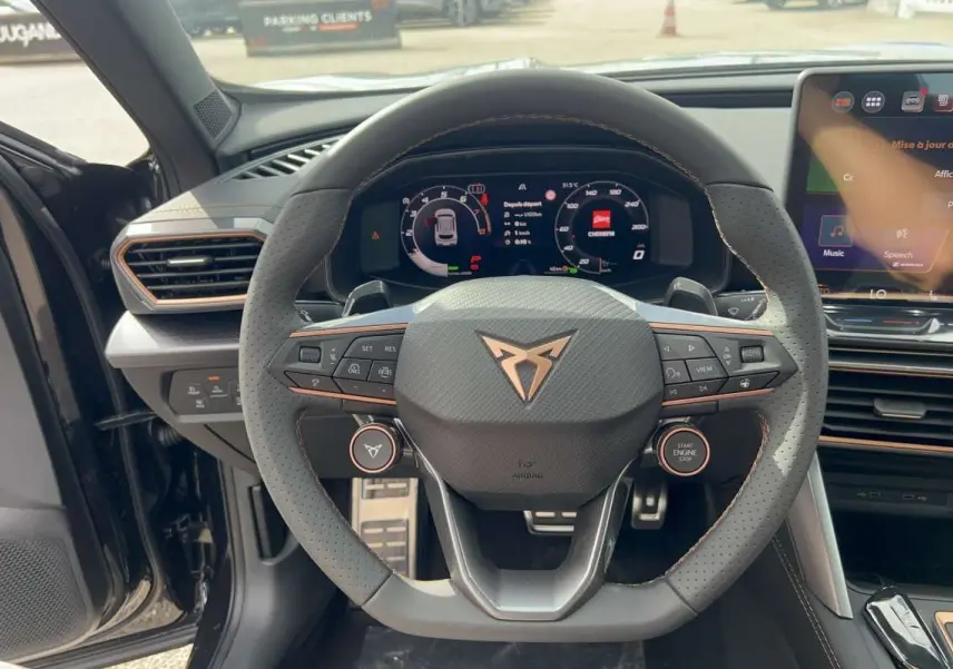 Vue intérieure centrée sur le volant cuir perforé noir minuit du CUPRA Formentor avec tableau de bord digital et écran tactile.
