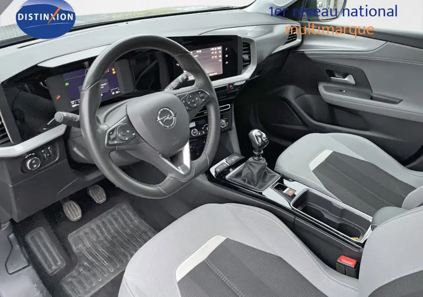 Intérieur de l'Opel Mokka 1.5 CDTI 2021 vu côté conducteur, tableau de bord moderne et sièges gris clair et noir.