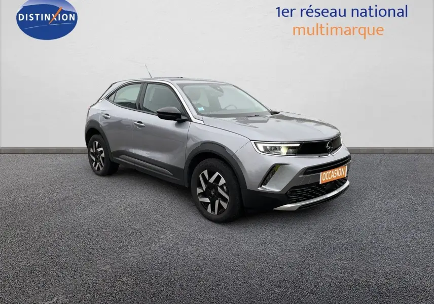 Opel Mokka gris Artens métal vue 3/4 avant droit, SUV compact avec jantes noires et phares LED allumés.