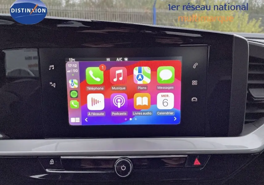 Écran tactile central allumé avec interface Apple CarPlay dans l'habitacle d'un Opel Mokka gris Artens 2021.