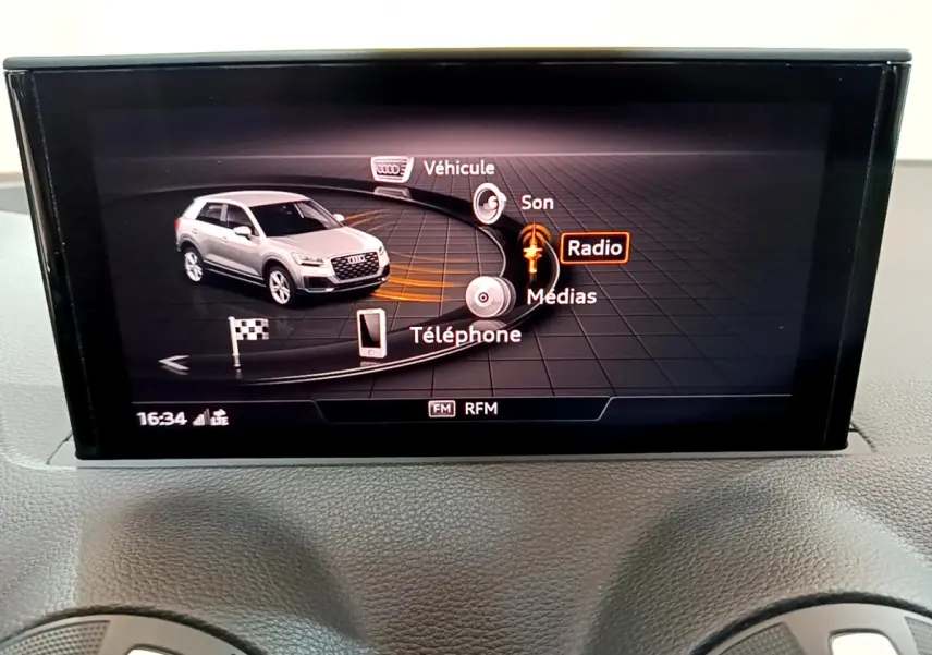 Écran central de l’Audi Q2 gris clair 2020 affichant le menu multimédia avec options Radio, Téléphone et Véhicule.