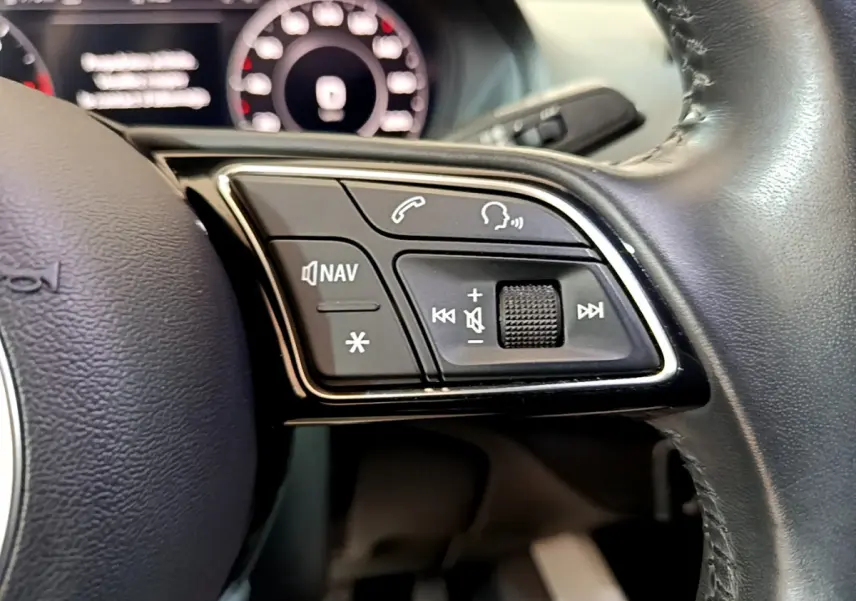 Gros plan sur les commandes multifonctions du volant cuir noir de l'Audi Q2 35 TDI 150 Design 2020.