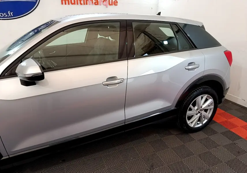 Vue latérale droite d'un Audi Q2 gris clair 2020, soulignant ses lignes anguleuses et ses jantes alliage.