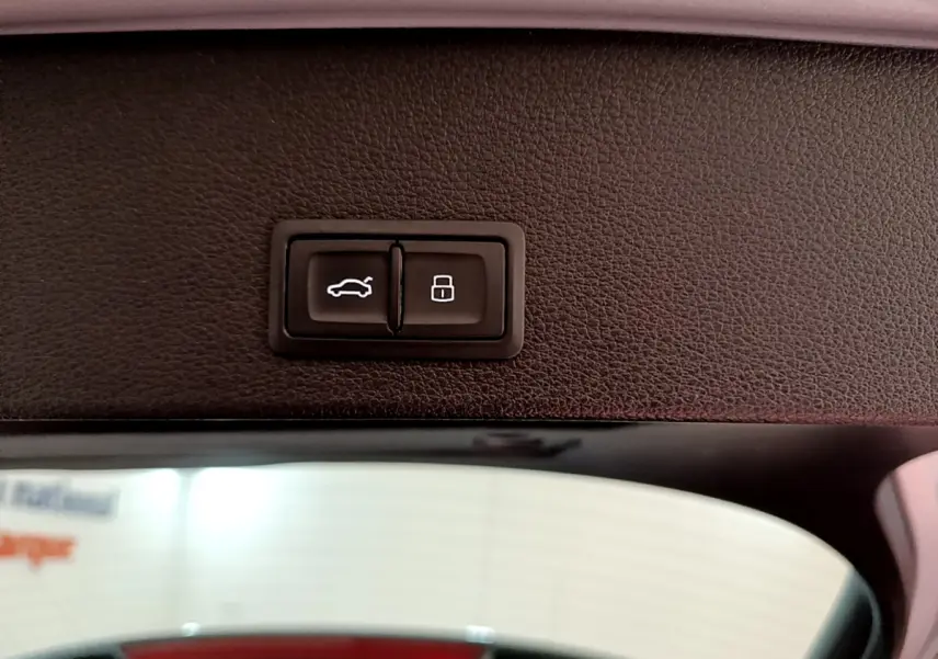 Gros plan sur les boutons d'ouverture et de verrouillage du coffre à l'intérieur d'un Audi Q2 gris clair 2020.