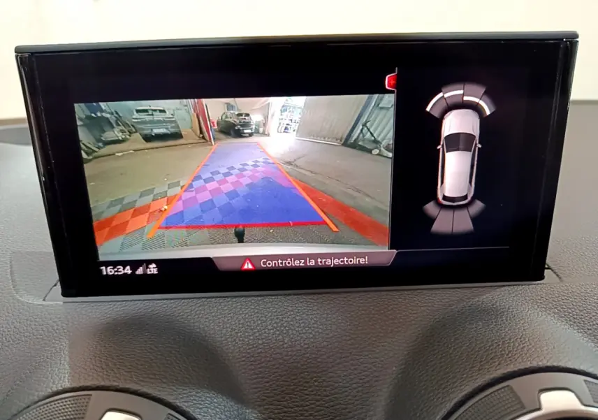 Écran multimédia de l'Audi Q2 35 TDI 150 Design 2020 montrant la caméra de recul et les capteurs de stationnement.