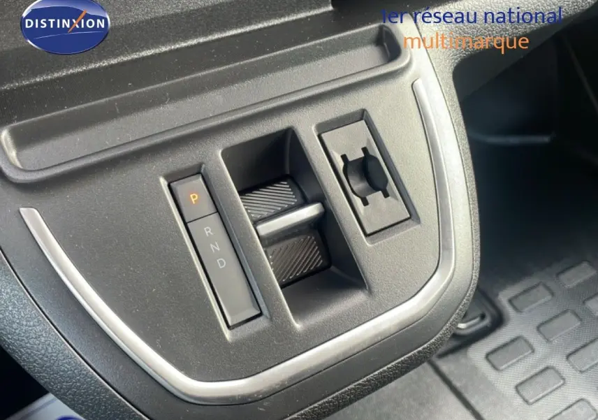 Gros plan sur la console centrale du Citroën Jumpy gris titane, montrant la commande de boîte automatique et un bouton rotatif.