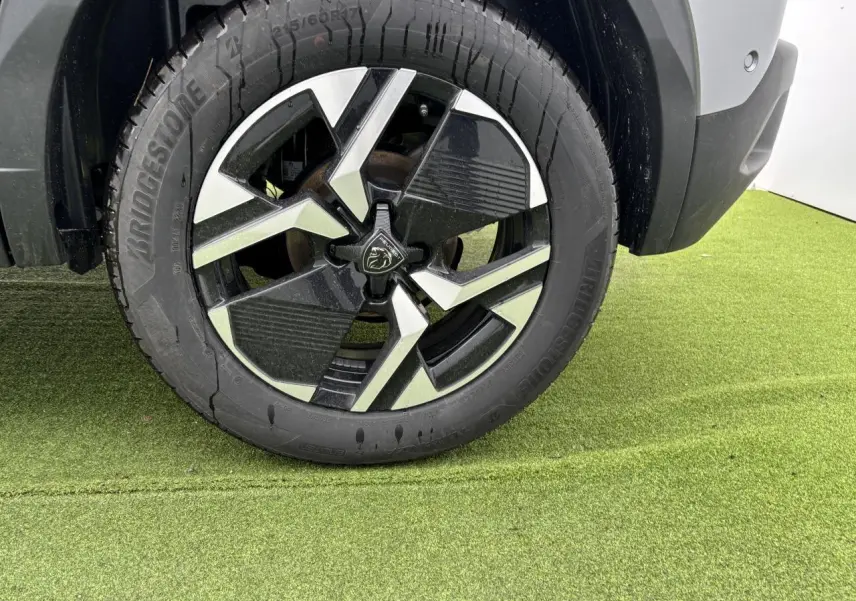 Gros plan sur la jante alliage 17'' bi-ton noir et argent du côté arrière droit du Peugeot 2008 gris Artense.