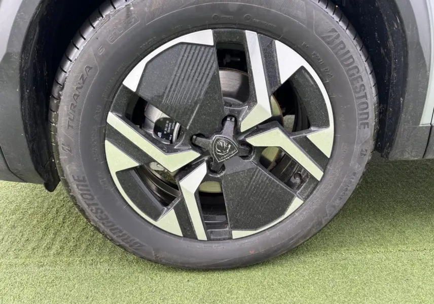 Gros plan sur la jante alliage bi-ton noir et gris du côté gauche d’un Peugeot 2008 gris Artense.