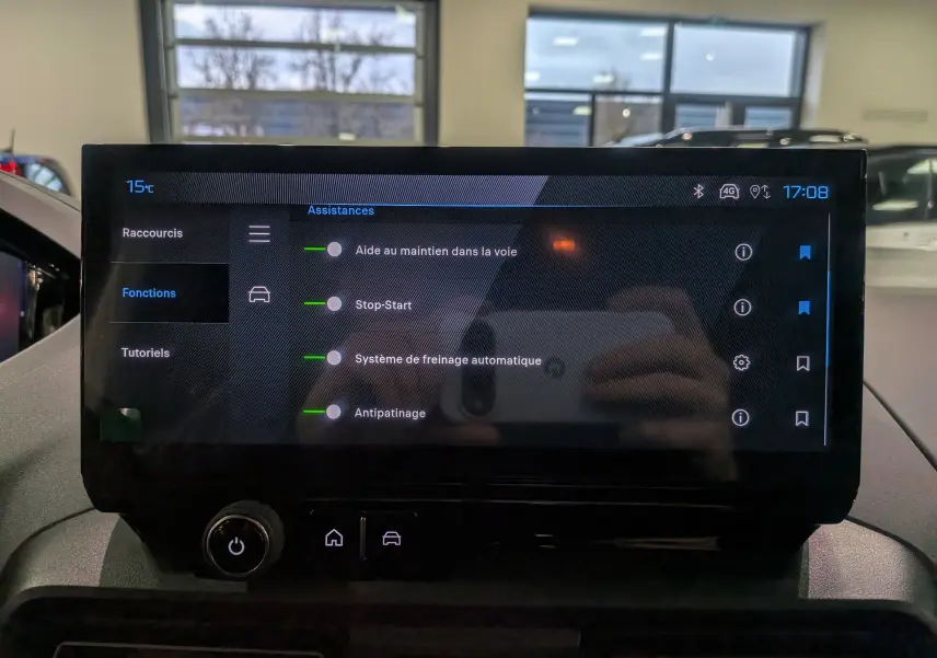 Écran tactile central du Peugeot Rifter 2025 affichant les assistances à la conduite, dans un intérieur sombre.