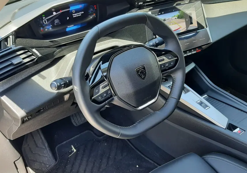 Vue intérieure côté conducteur du Peugeot 408 Hybrid 145ch Allure 2024, volant compact et tableau de bord numérique.