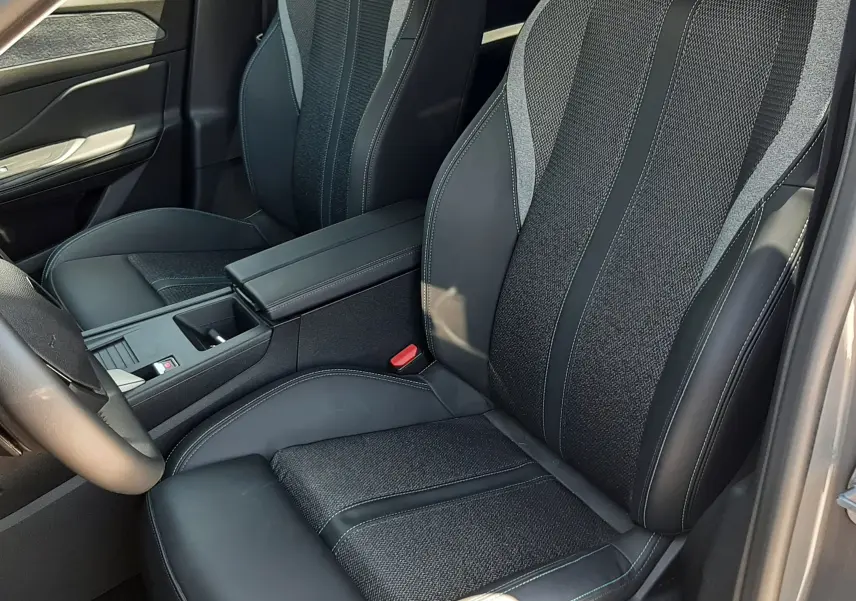 Vue intérieure côté conducteur de la Peugeot 408 Hybrid 145ch Allure 2024, sièges tissu et cuir gris avec surpiqûres contrastées.