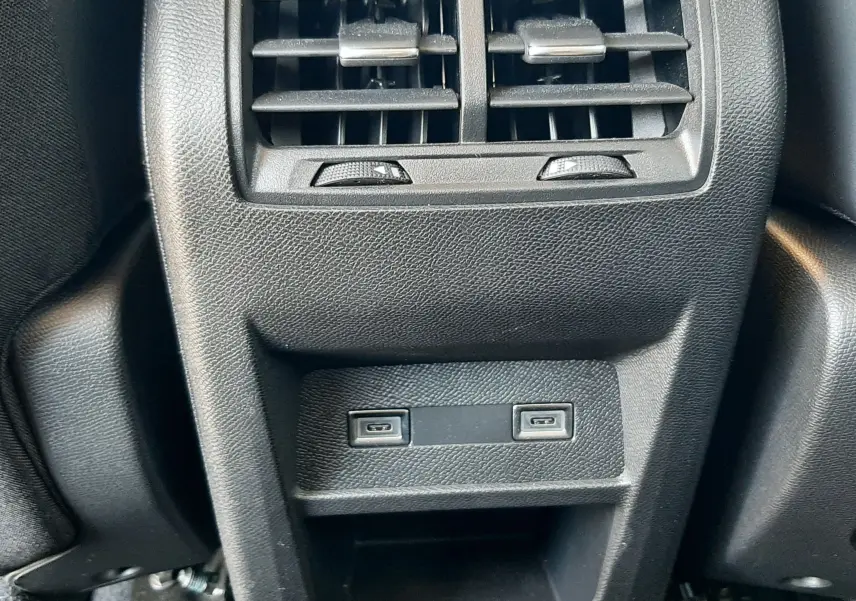 Vue rapprochée des aérateurs arrière et ports USB du Peugeot 408 Hybrid 145ch Allure gris Selenium, intérieur noir.