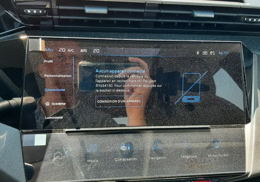 Vue rapprochée de l'écran tactile central du tableau de bord du Peugeot 408 gris sélénium, affichant les options de connectivité.