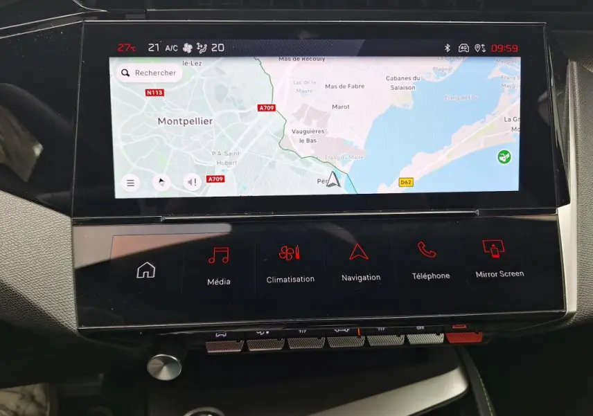 Vue rapprochée de l'écran tactile central et de la console multimédia du Peugeot 308 Hybrid 145 e-DCS6 GT gris 2025.