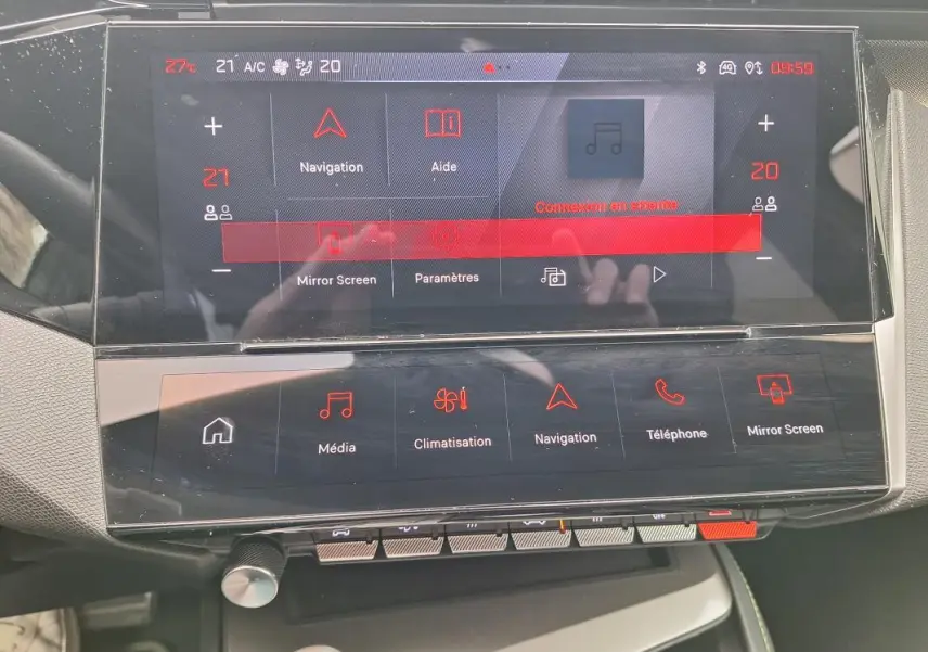 Vue rapprochée du tableau de bord numérique et de l’écran tactile central du Peugeot 308 Hybrid 145 e-DCS6 GT gris 2025.