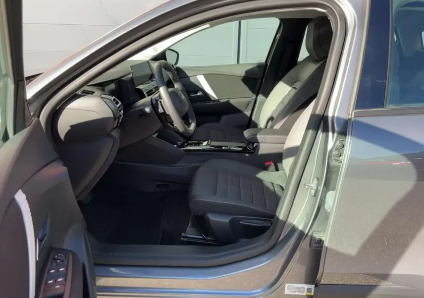 Intérieur de la Citroën C4 hybride gris mercury vu côté conducteur, montrant sièges et tableau de bord moderne.