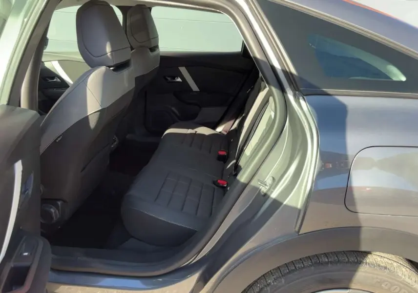 Vue intérieure côté gauche sur la banquette arrière et la portière ouverte d'une Citroën C4 hybride gris mercury.
