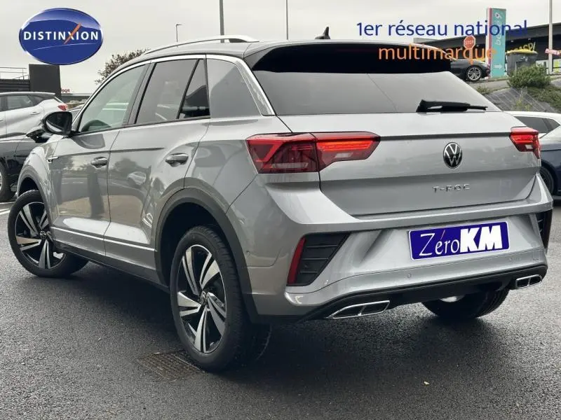 Vue 3/4 arrière droite d'un Volkswagen T-Roc gris 2025 finition R-Line avec feux LED et double sortie d'échappement.