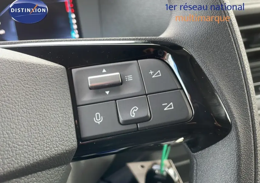 Gros plan sur les commandes au volant du Citroën Jumpy gris titane, avec boutons de volume et téléphone visibles.