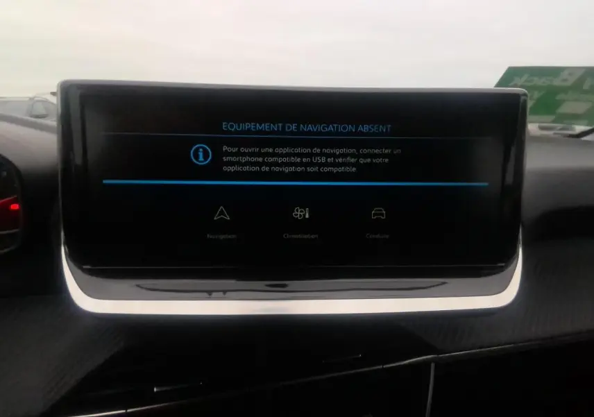 Écran central tactile affichant l'absence d'équipement de navigation dans une Peugeot 208 gris clair, vue intérieure.