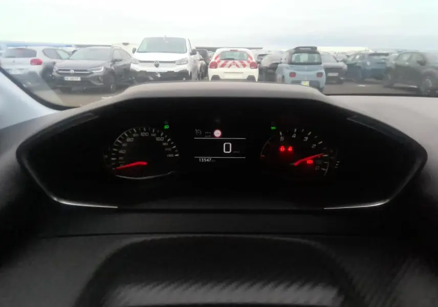 Vue intérieure du tableau de bord de la Peugeot 208 gris clair 2024, affichant le compteur digital à zéro km/h.