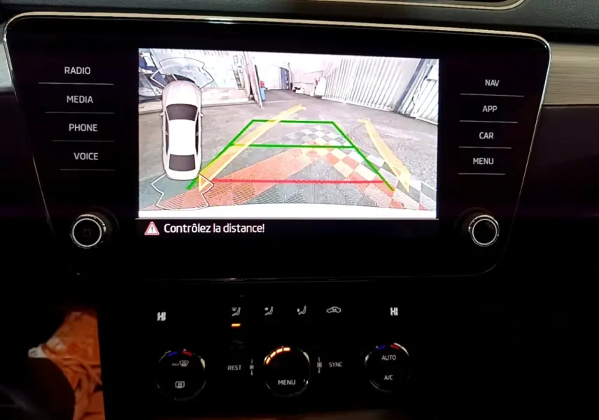 Affichage de la caméra de recul sur écran tactile du tableau de bord d'une Skoda Superb blanche, vue intérieure centrale.