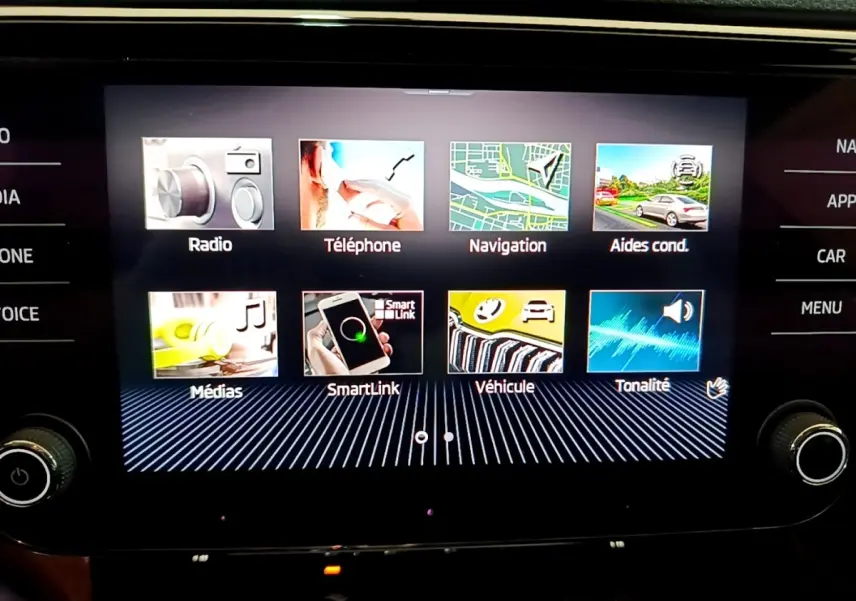 Écran tactile central affichant le menu multimédia de la Skoda Superb 2.0 TDI blanc, vue de face en intérieur.
