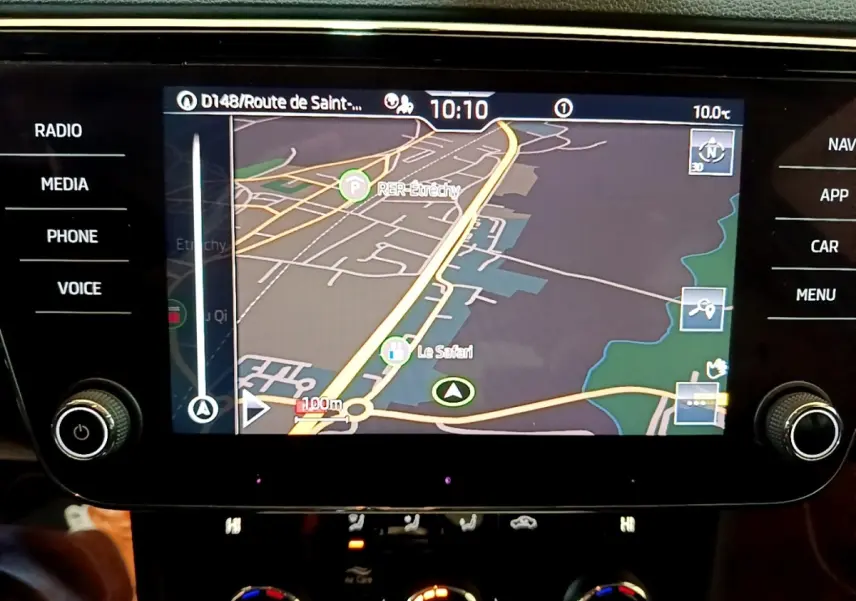 Écran tactile central du tableau de bord de la Skoda Superb blanc, affichant la navigation GPS en couleur.