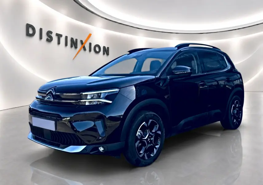 Citroën C5 Aircross noir vue 3/4 avant droit avec jantes alu et barres de toit en showroom lumineux.