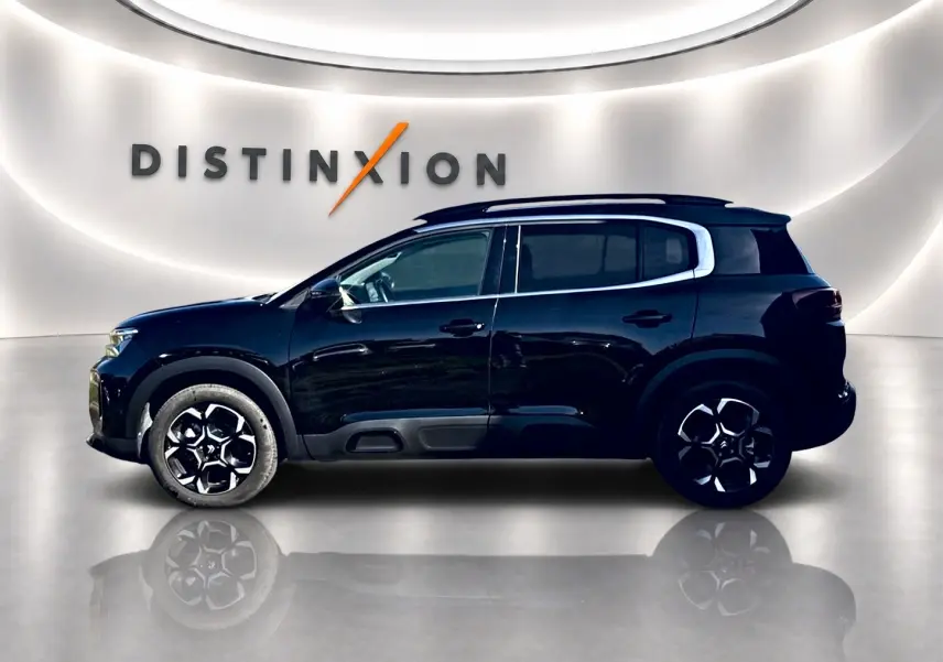 Profil côté gauche du Citroën C5 Aircross noir 2025 avec jantes alu et barres de toit visibles en showroom.
