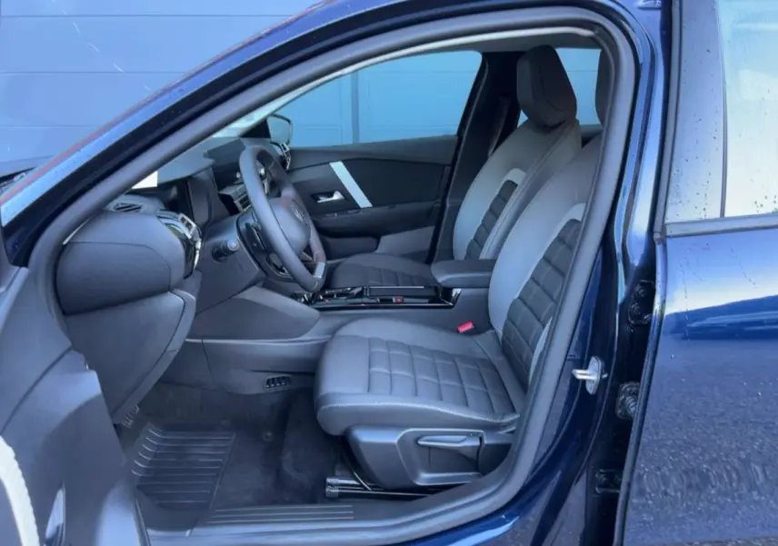 Intérieur avant de la Citroën C4 hybride bleu eclipse, vue côté gauche montrant sièges et tableau de bord modernes.