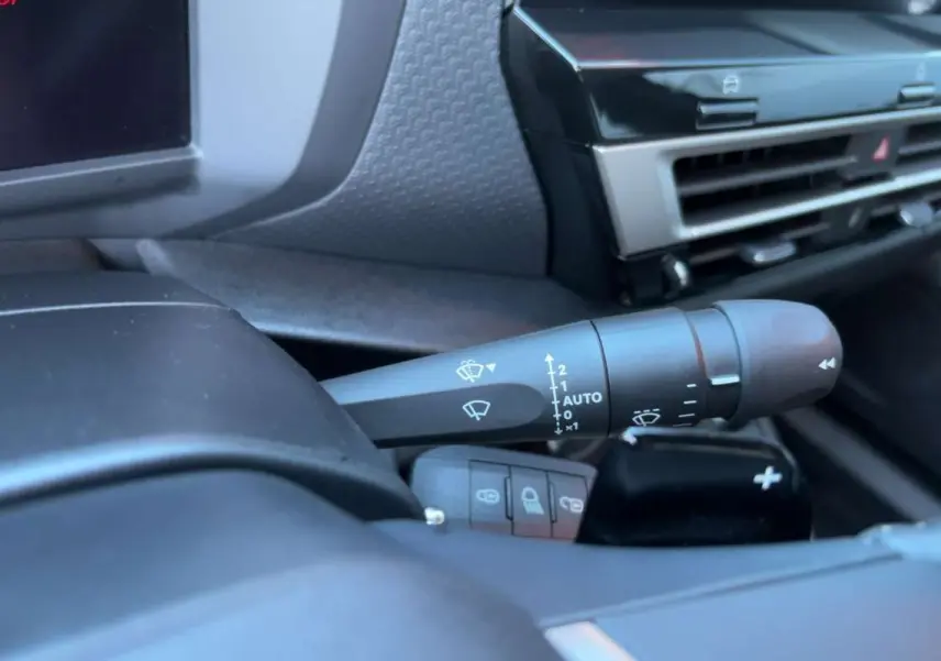 Gros plan sur la commande d’essuie-glace côté droit du tableau de bord d’une Citroën C4 hybride bleu eclipse.