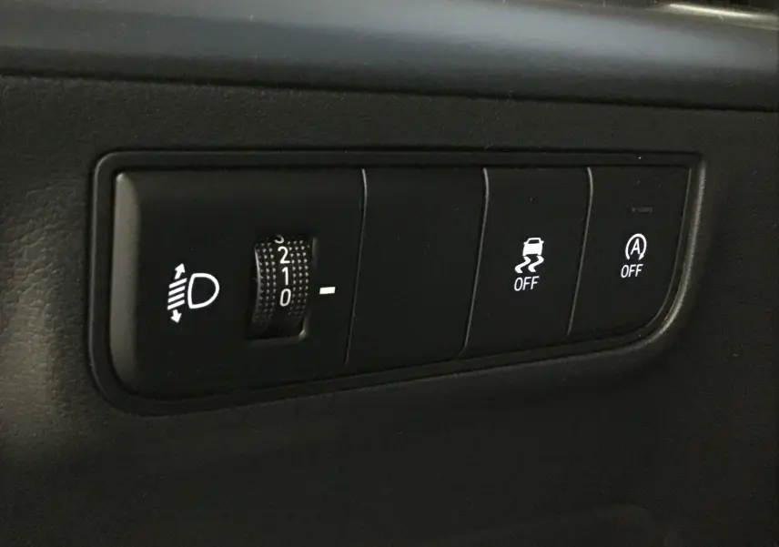 Gros plan sur les commandes d'assistance à la conduite du Hyundai Tucson 2025, avec réglage des phares et désactivation ESP.