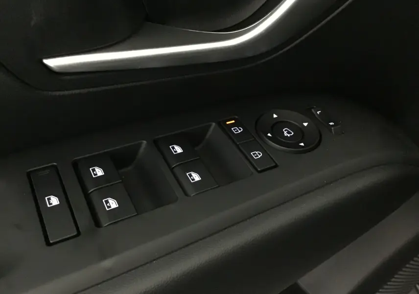 Gros plan sur les commandes de lève-vitres et rétroviseurs côté conducteur d'un Hyundai Tucson rouge Ultimate 2025.