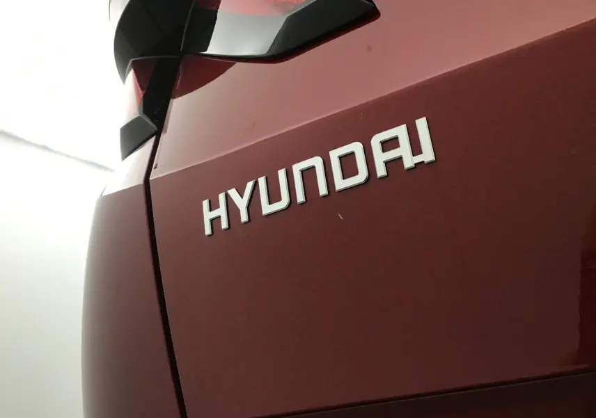 Gros plan sur l'arrière rouge Ultimate d'un Hyundai Tucson 2025, mettant en valeur le logo Hyundai et le feu arrière.