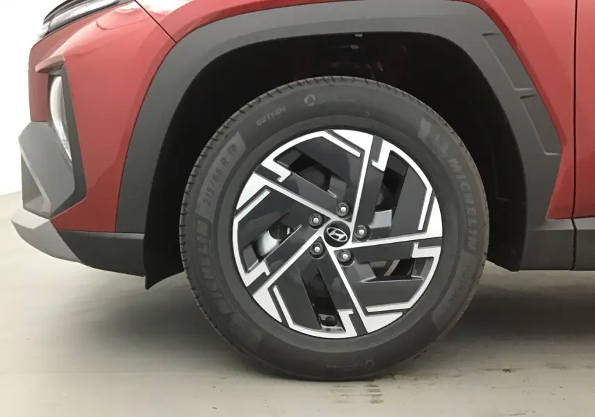 Gros plan sur la roue avant gauche du Hyundai Tucson 2025 rouge Ultimate, mettant en valeur la jante alliage 17 pouces au design moderne.