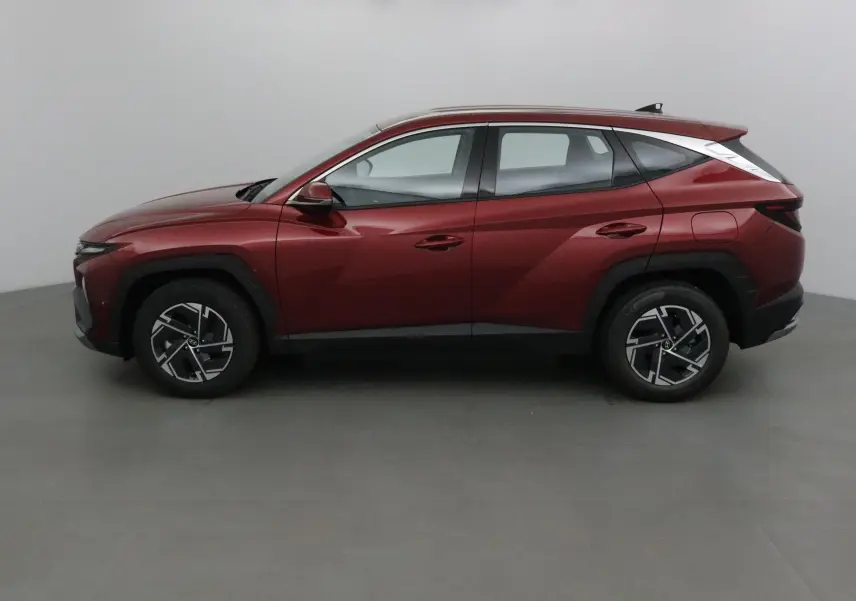 Profil côté gauche du Hyundai Tucson 2025 rouge Ultimate avec jantes alliage et lignes anguleuses marquées.