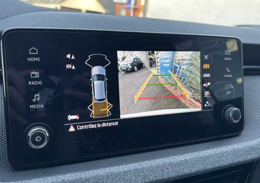Écran central du Skoda Kamiq 2025 montrant la caméra de recul avec guidage de trajectoire en couleur gris argent.