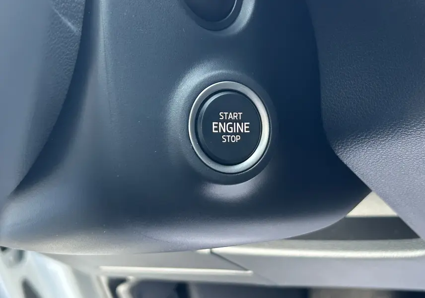 Gros plan sur le bouton Start Engine Stop noir entouré de gris dans l'habitacle du Skoda Kamiq 2025 gris argent.