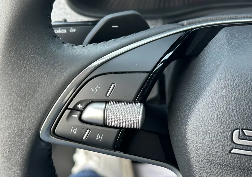 Gros plan sur la molette de réglage du volume et les commandes vocales au volant du Skoda Kamiq gris argent 2025.