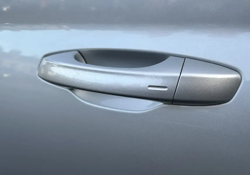 Poignée de porte côté gauche gris argent métallisé d'un Skoda Kamiq 2025, finition lisse avec capteur intégré.