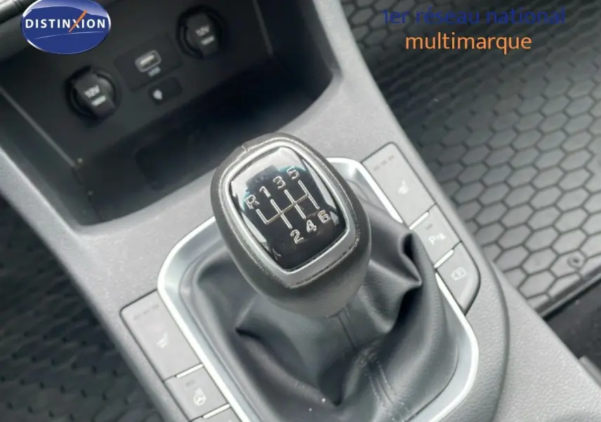 Le levier de vitesses manuel de la Hyundai i30 SW 2023 en gros plan, entouré de commandes et prises USB.