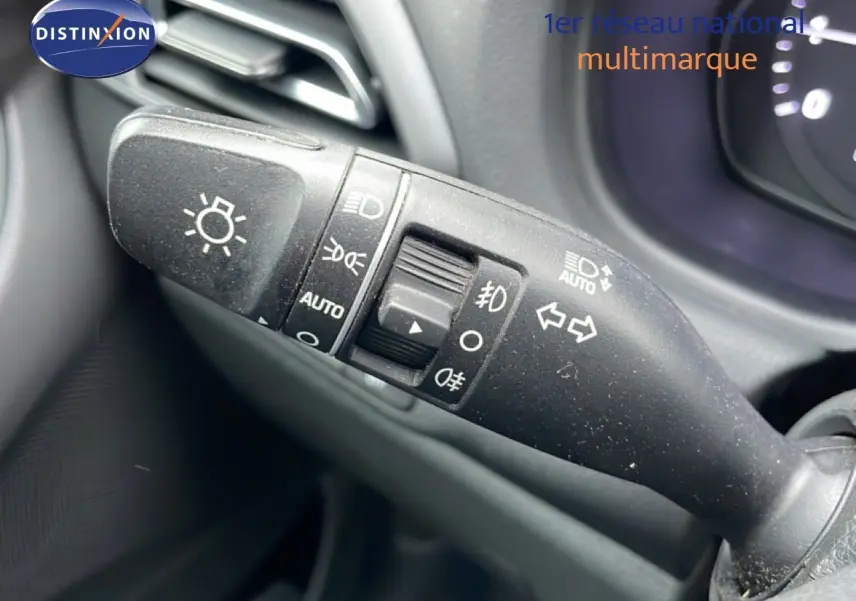 Gros plan sur la commande des feux et clignotants à gauche du volant dans l'habitacle d'une Hyundai i30 SW blanche.